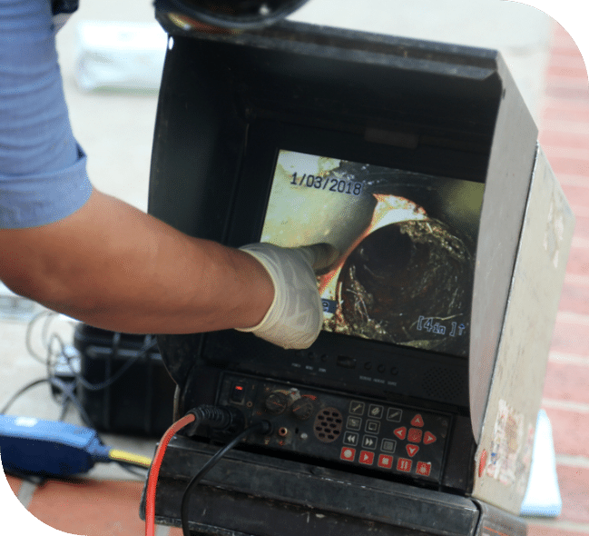 Plumber inspecting a pipe with a CCTV camera for internal blockage